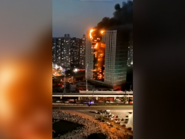 Fire tears through Chinese skyscraper as debris falls onto streets below (VIDEO)