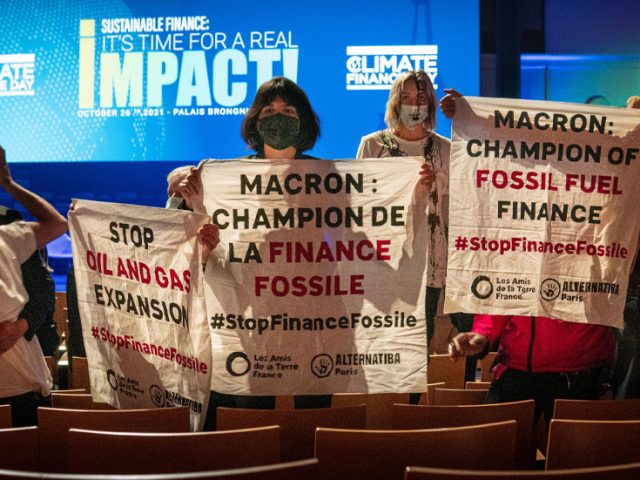 Climate activists detained after disrupting summit to accuse French govt of championing ‘fossil fuel finance’